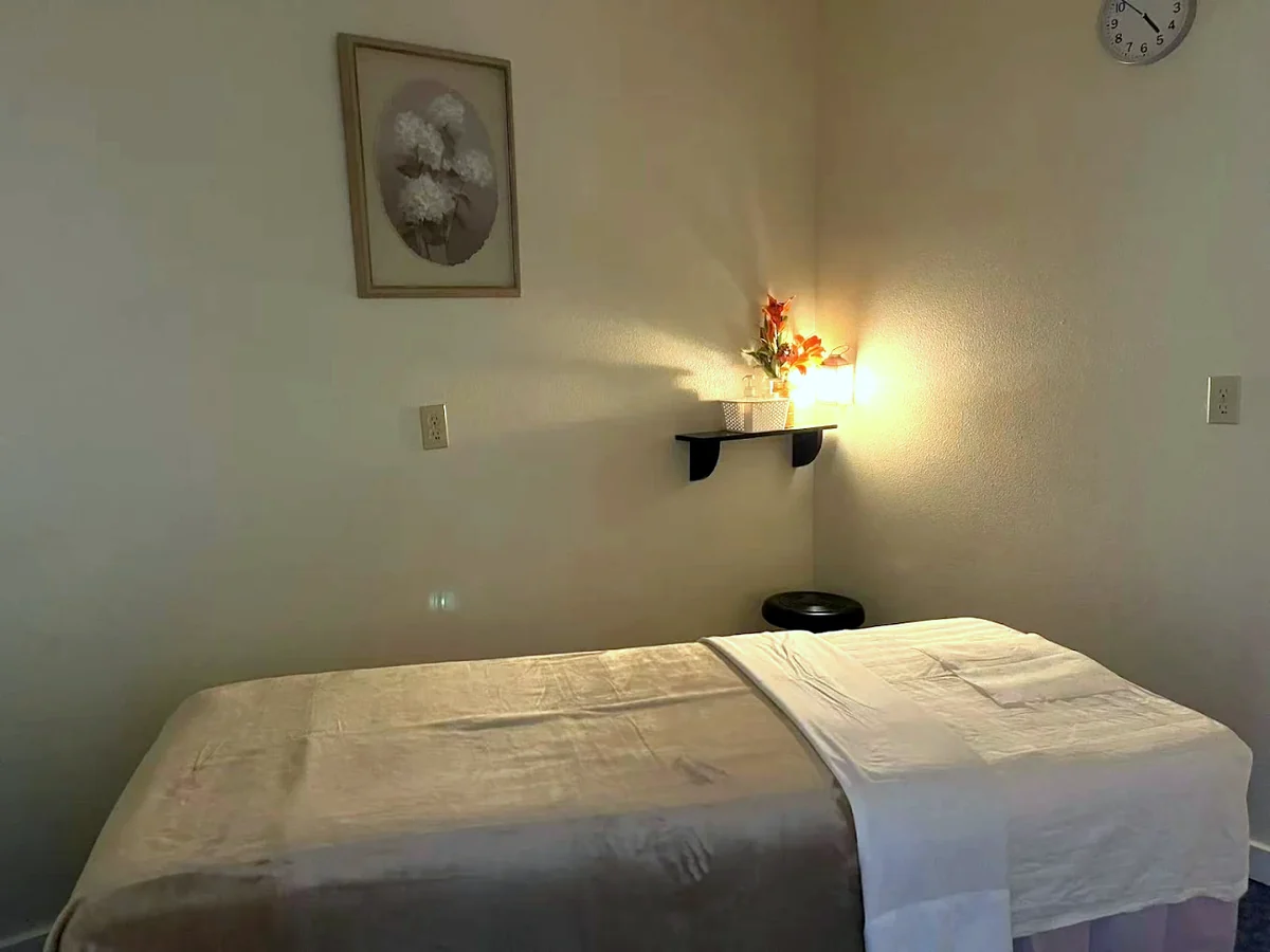 A West Valley Massage treatment room lit by a single warm lantern
