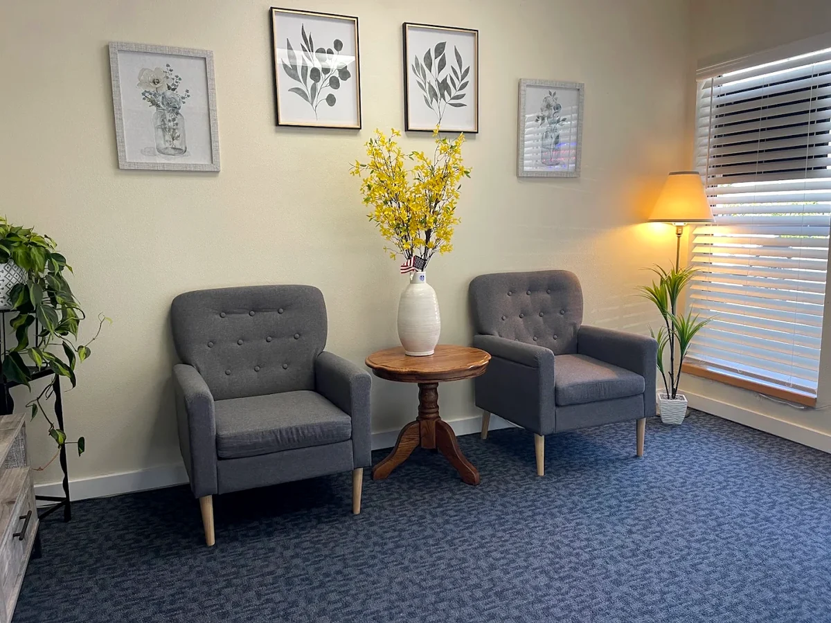 The waiting area at West Valley Massage in Forest Grove, with two armchairs, plants and a window